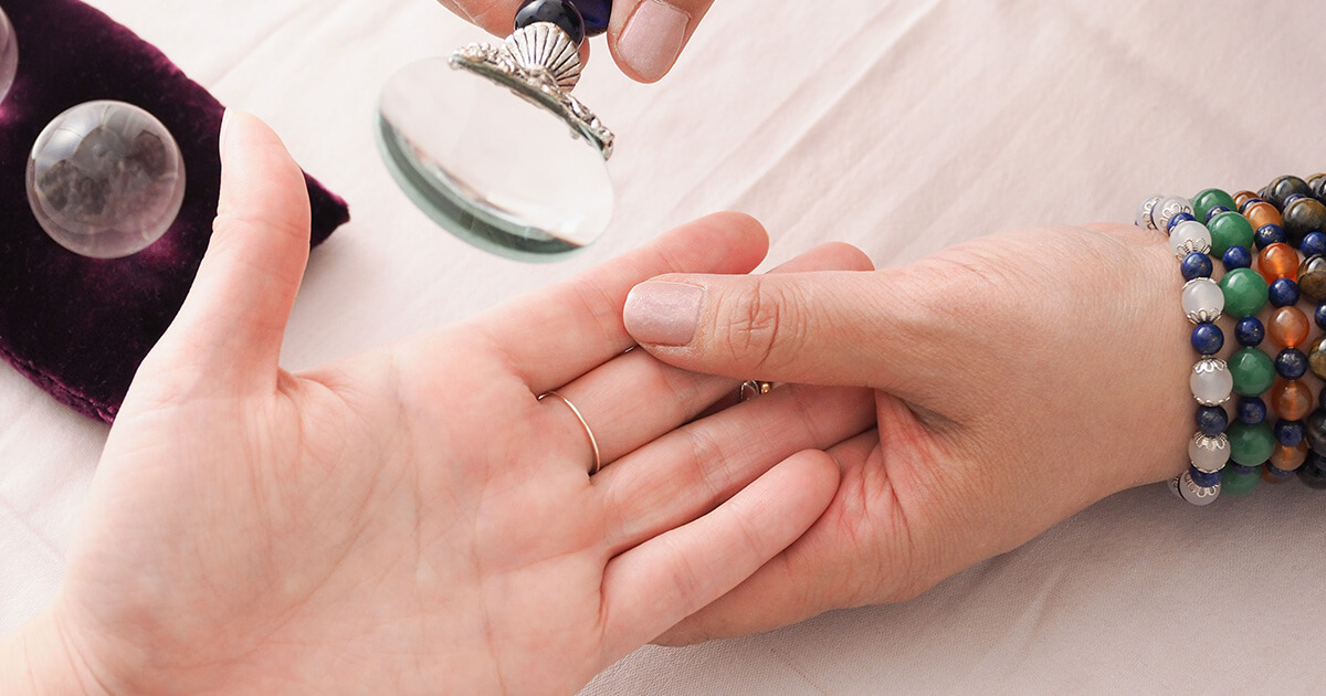 四柱推命の占いで手相を見てもらう様子